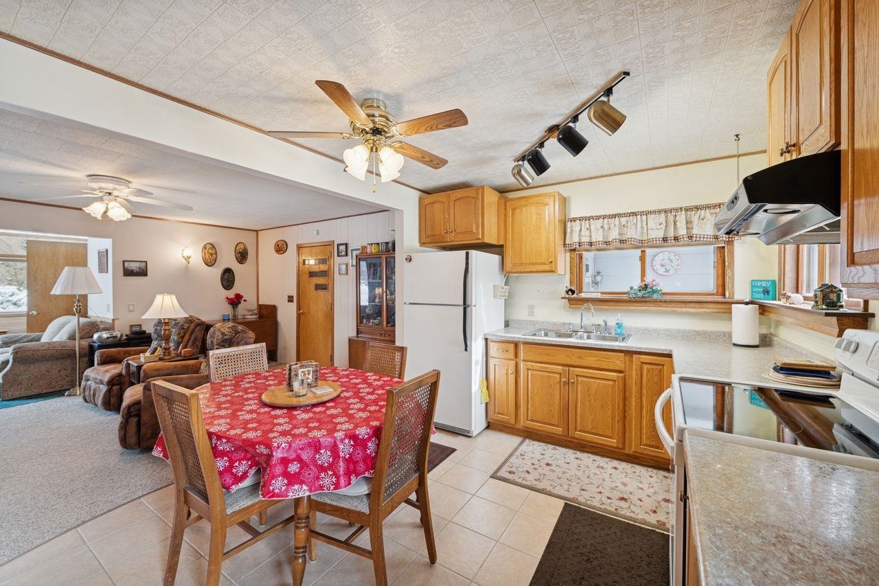 65915 Selke Road Mason, WI 54856 - Photo 9 of 33 Dining room featuring a ceiling fan, track lighting, crown molding, and light tile patterned floors