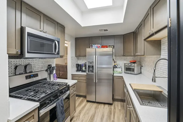 a kitchen with stainless steel appliances granite countertop a stove microwave and a refrigerator