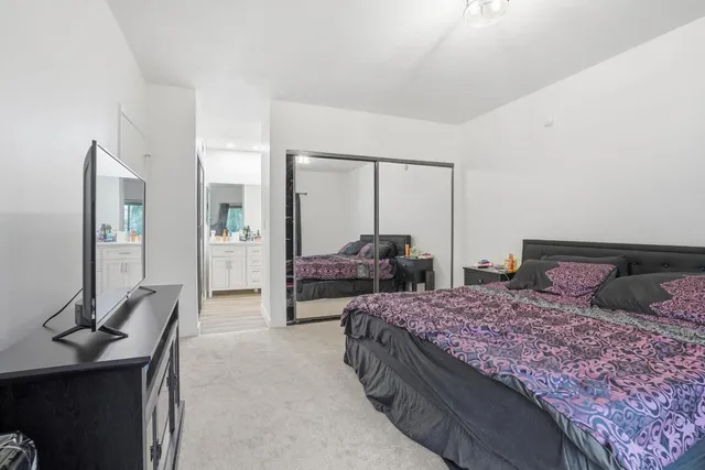 a bedroom with a bed and large mirror