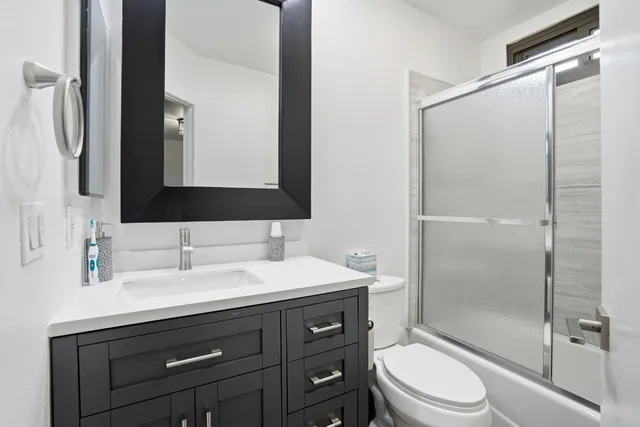 a bathroom with a sink a toilet and shower