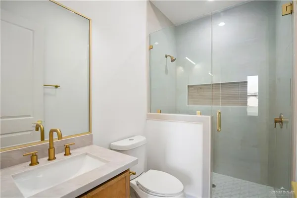 a bathroom with a sink a toilet and shower