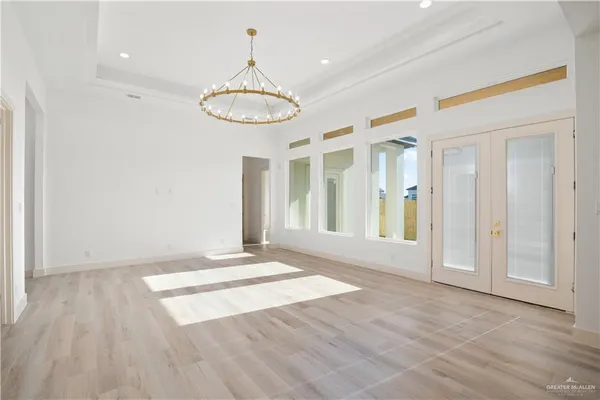 a view of a large kitchen with a large window wooden floor and stainless steel appliances