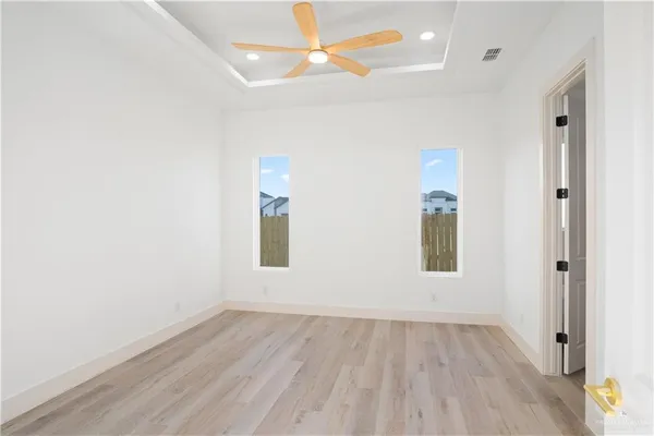 an empty room with a window and wooden floor