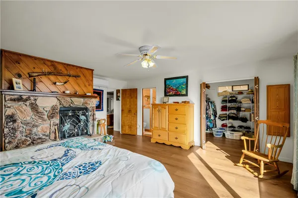 a bedroom with a bed dresser and a large window