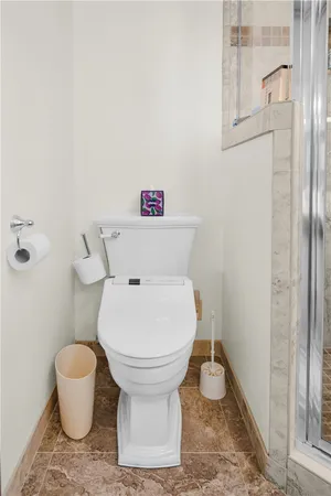 a bathroom with a toilet and a shower