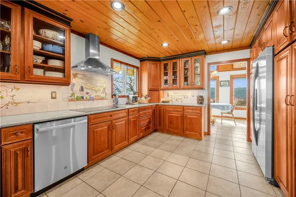 a large kitchen with stainless steel appliances granite countertop a sink and cabinets