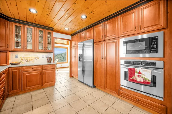 a kitchen with stainless steel appliances granite countertop a refrigerator a stove top oven and cabinets