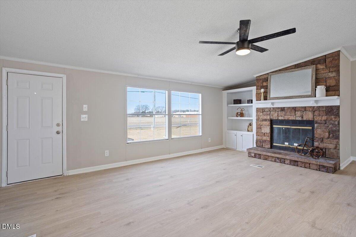 371 Woodland Church Road Dudley, NC 28333 - Photo 16 of 30 a view of a livingroom with a ceiling fan fireplace and windows