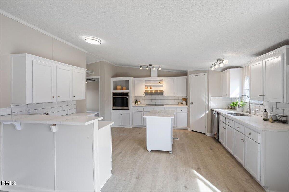 371 Woodland Church Road Dudley, NC 28333 - Photo 4 of 30 a kitchen with white cabinets and white appliances