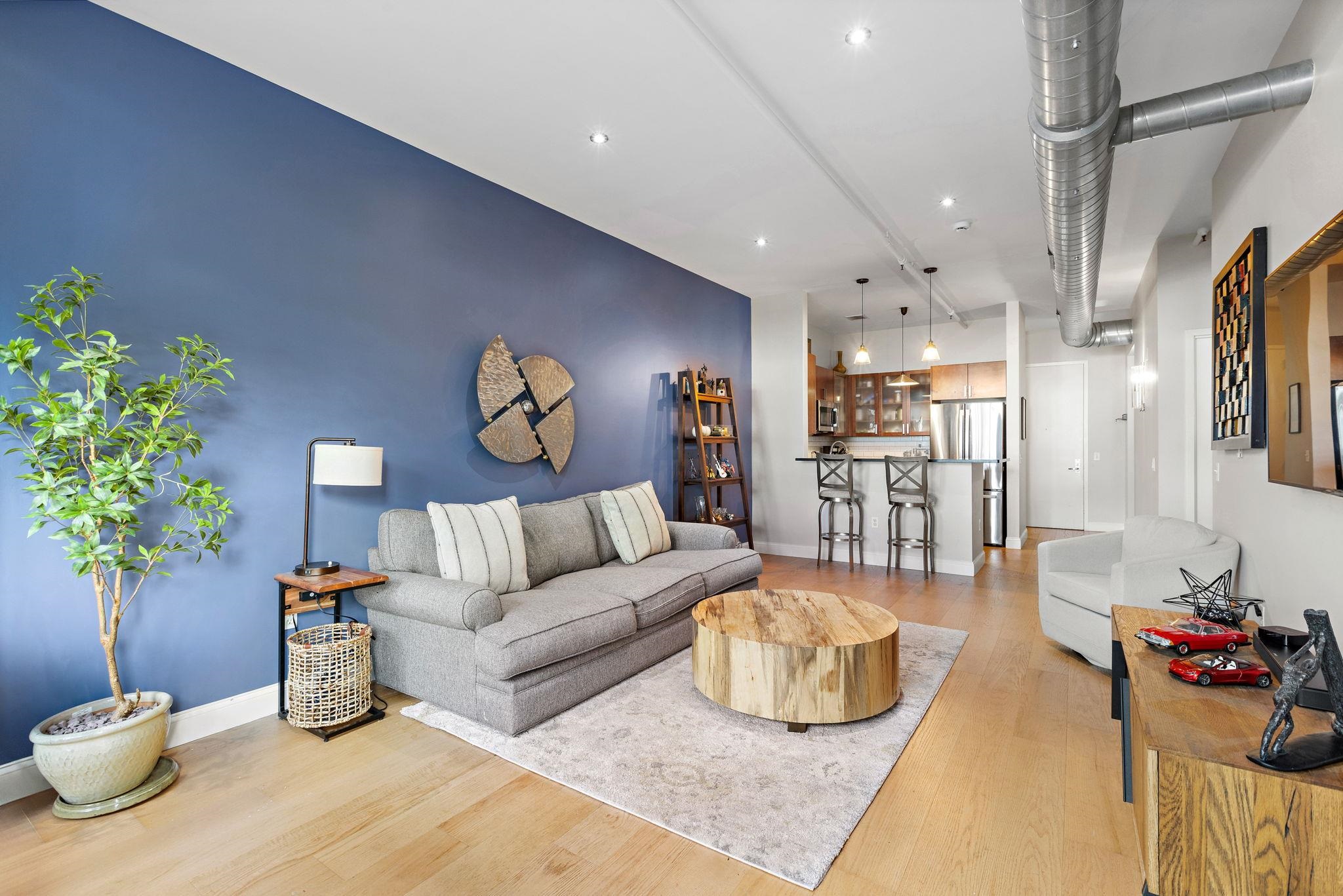 234 10th Street, Unit 306 Jersey City, NJ 07302 - Photo 3 of 15 a living room with furniture and a chandelier
