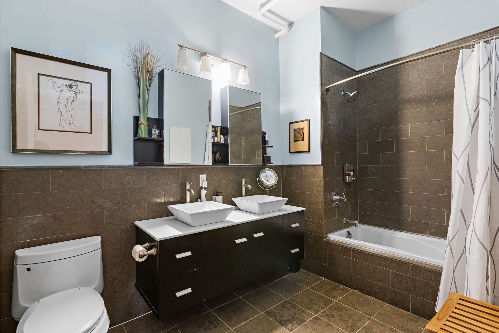 234 10th Street, Unit 306 Jersey City, NJ 07302 - Photo 9 of 15 a bathroom with a double vanity sink toilet and shower