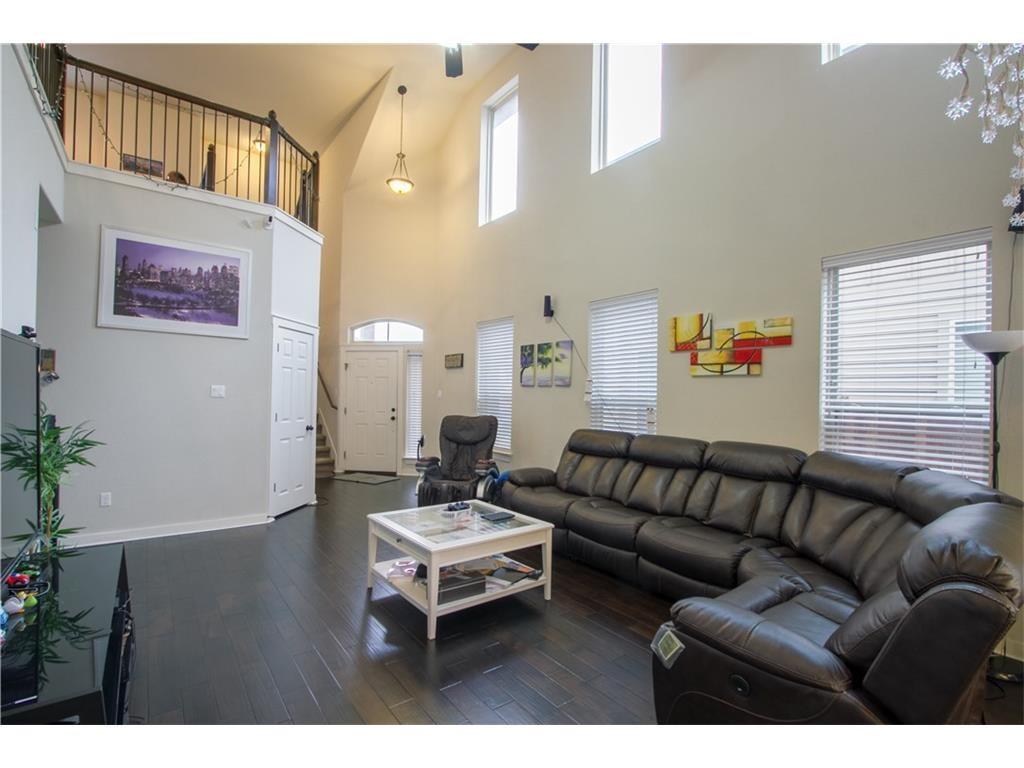 16309 McAloon Way Austin, TX 78728 - Photo 4 of 16 Living room featuring dark wood-style flooring, healthy amount of natural light, and a towering ceiling