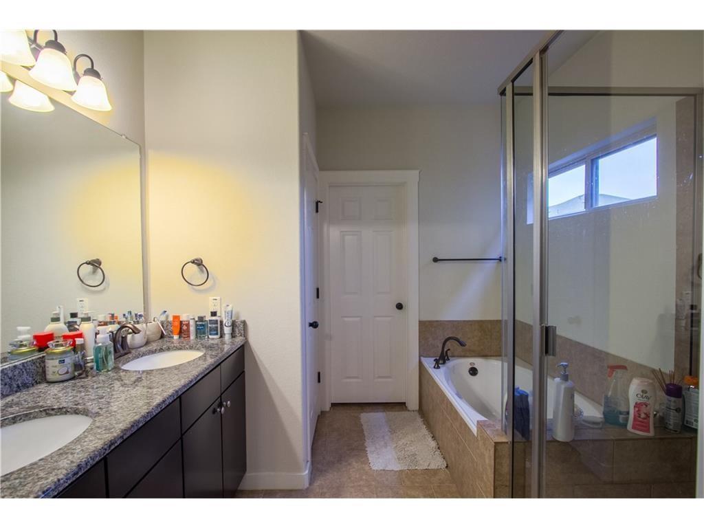 16309 McAloon Way Austin, TX 78728 - Photo 7 of 16 Bathroom with a shower stall, double vanity, and a garden tub