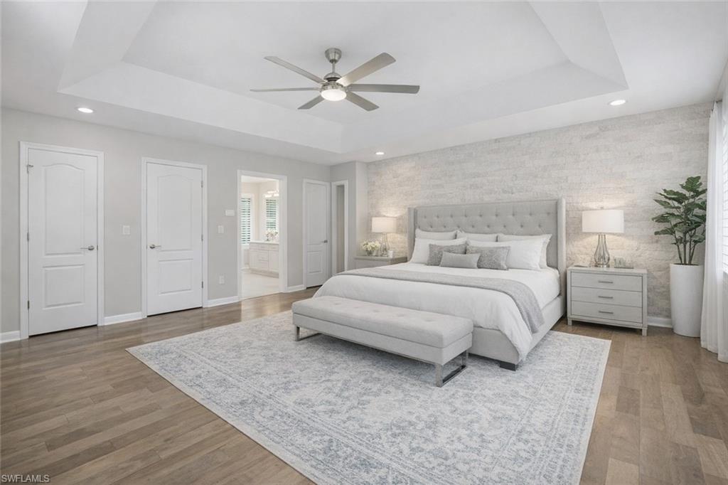 7395 Stonegate Drive Naples, FL 34109 - Photo 26 of 45 a bedroom with a large bed and a ceiling fan