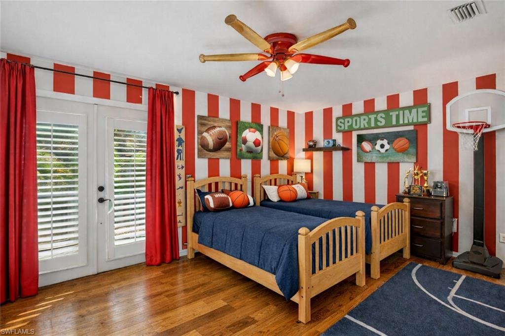 7395 Stonegate Drive Naples, FL 34109 - Photo 28 of 45 a bedroom with a bed and a chandelier