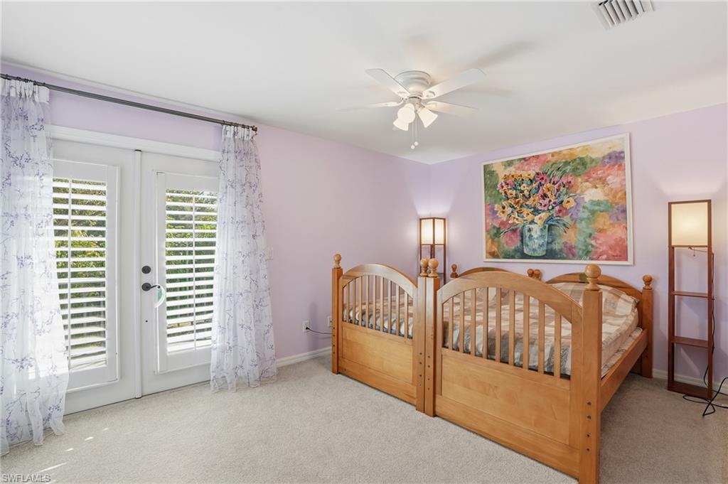 7395 Stonegate Drive Naples, FL 34109 - Photo 29 of 45 a bedroom with a bed and a chandelier