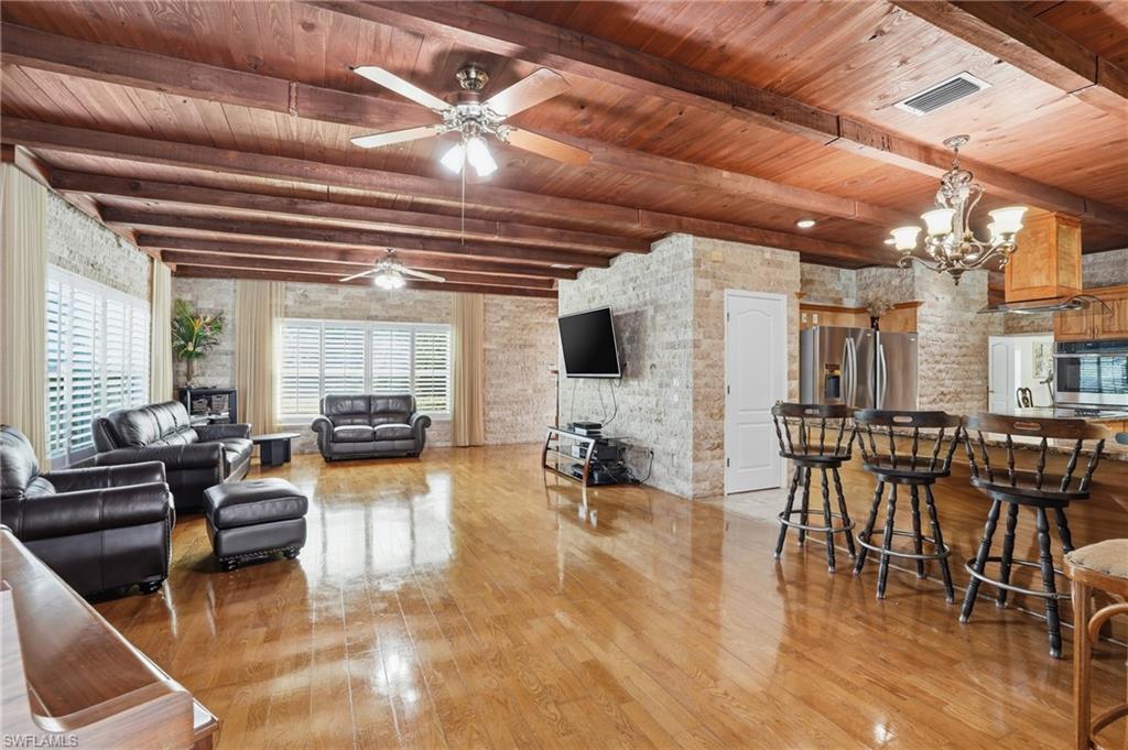 7395 Stonegate Drive Naples, FL 34109 - Photo 10 of 45 a living room with furniture and a flat screen tv