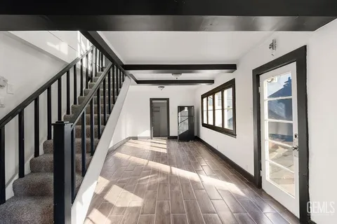 a view of an empty room with wooden floor