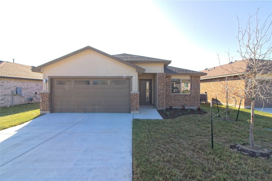112 Halford Road Georgetown, TX 78633 - Photo 1 of 37 View of front of house with a front lawn, concrete driveway, an attached garage, and brick siding