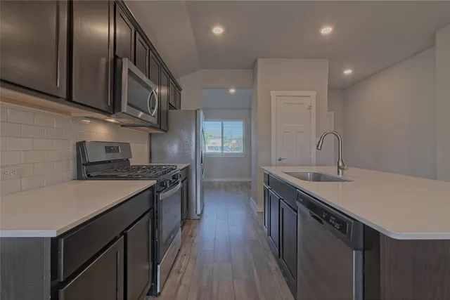 a kitchen with stainless steel appliances granite countertop a sink stove and cabinets
