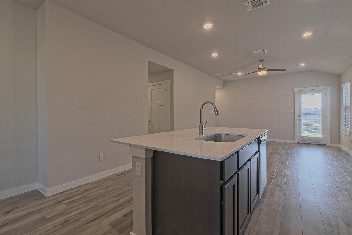112 Halford Road Georgetown, TX 78633 - Photo 8 of 37 Kitchen with vaulted ceiling, light wood finished floors, light stone countertops, a ceiling fan, and recessed lighting