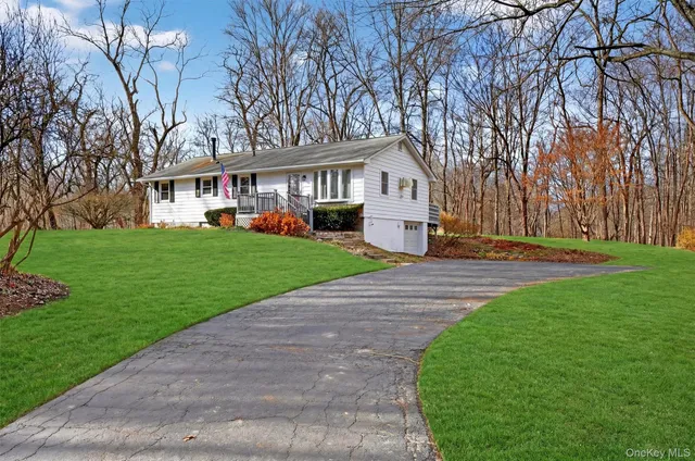 a front view of a house with a yard and trees