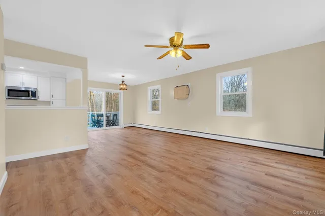 a view of a livingroom with wooden floor and a ceiling fan