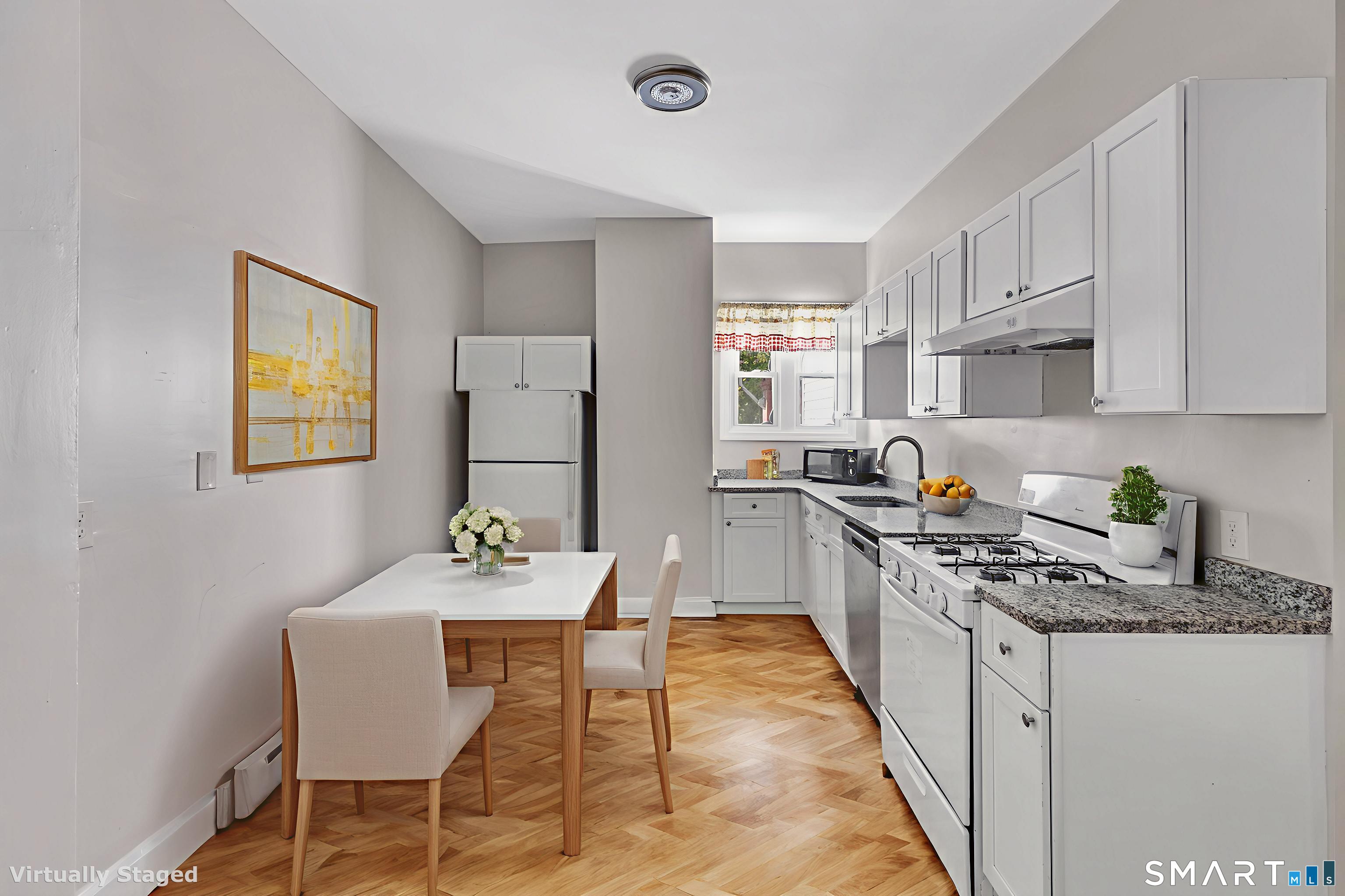 82-86 Water Street, Unit 2 Torrington, CT 06790 - Photo 2 of 23 a kitchen with stainless steel appliances granite countertop a stove a sink dishwasher a dining table and chairs with wooden floor