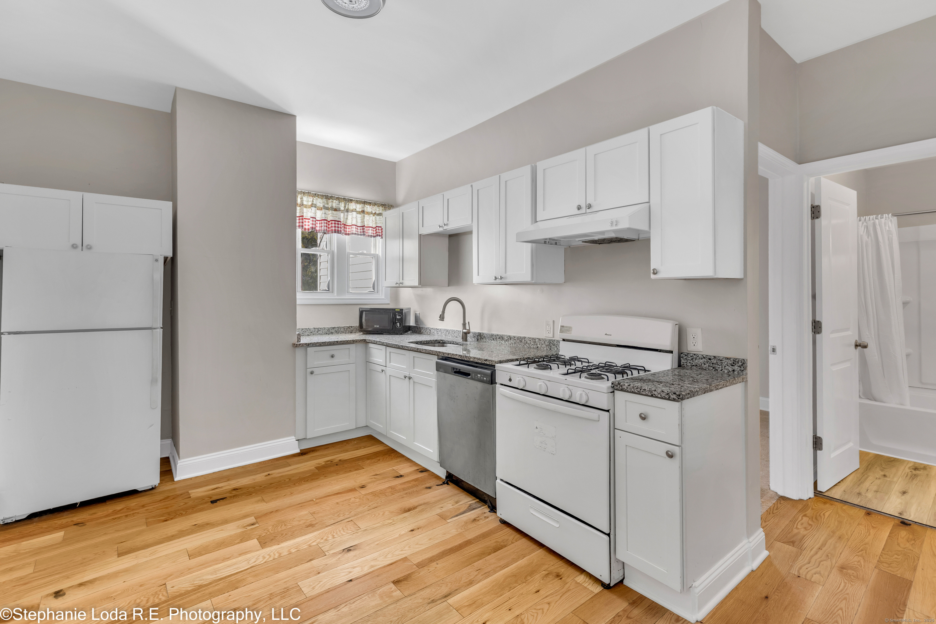 82-86 Water Street, Unit 2 Torrington, CT 06790 - Photo 9 of 23 a kitchen with stainless steel appliances granite countertop a stove a refrigerator and a refrigerator