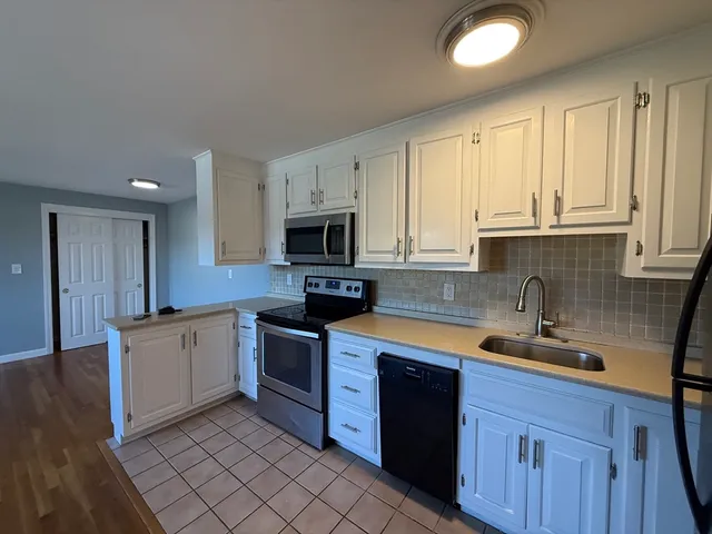 a kitchen with stainless steel appliances granite countertop a sink stove and cabinets