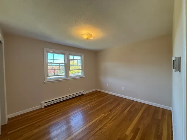 a view of a room with wooden floor and windows