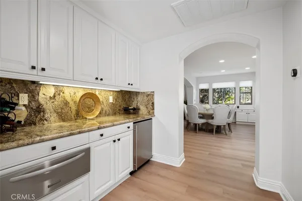 a kitchen with kitchen island granite countertop a stove a sink a center island and cabinets