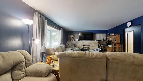a living room with furniture a large window and a flat screen tv