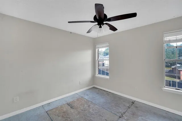 a view of a room with a ceiling fan and a window