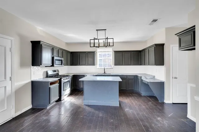 a kitchen with a sink cabinets and wooden floor