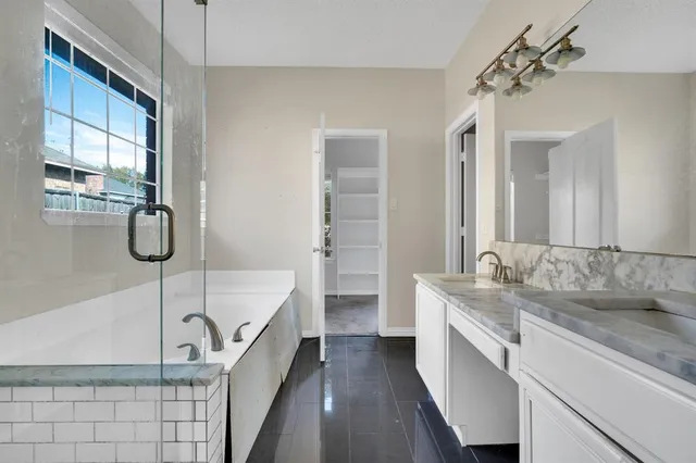 a bathroom with a granite countertop sink a mirror and shower