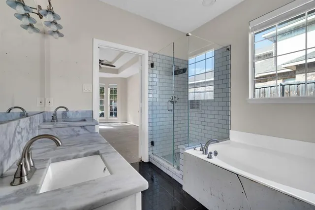 a bathroom with a tub a sink and a large mirror