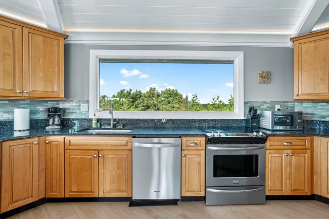 a kitchen with granite countertop white cabinets and white appliances