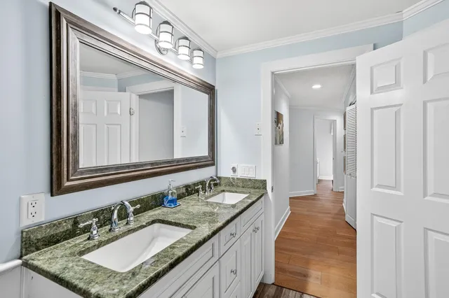 a bathroom with a granite countertop double vanity sink and a mirror