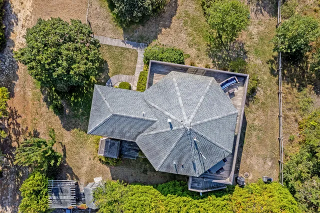an aerial view of a house with roof deck and table under an umbrella