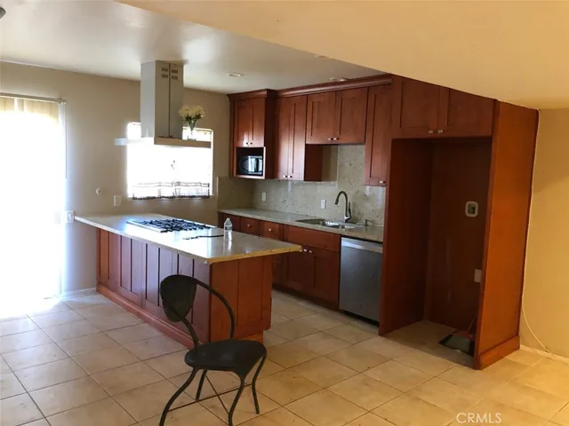 a kitchen with granite countertop a sink cabinets and stainless steel appliances
