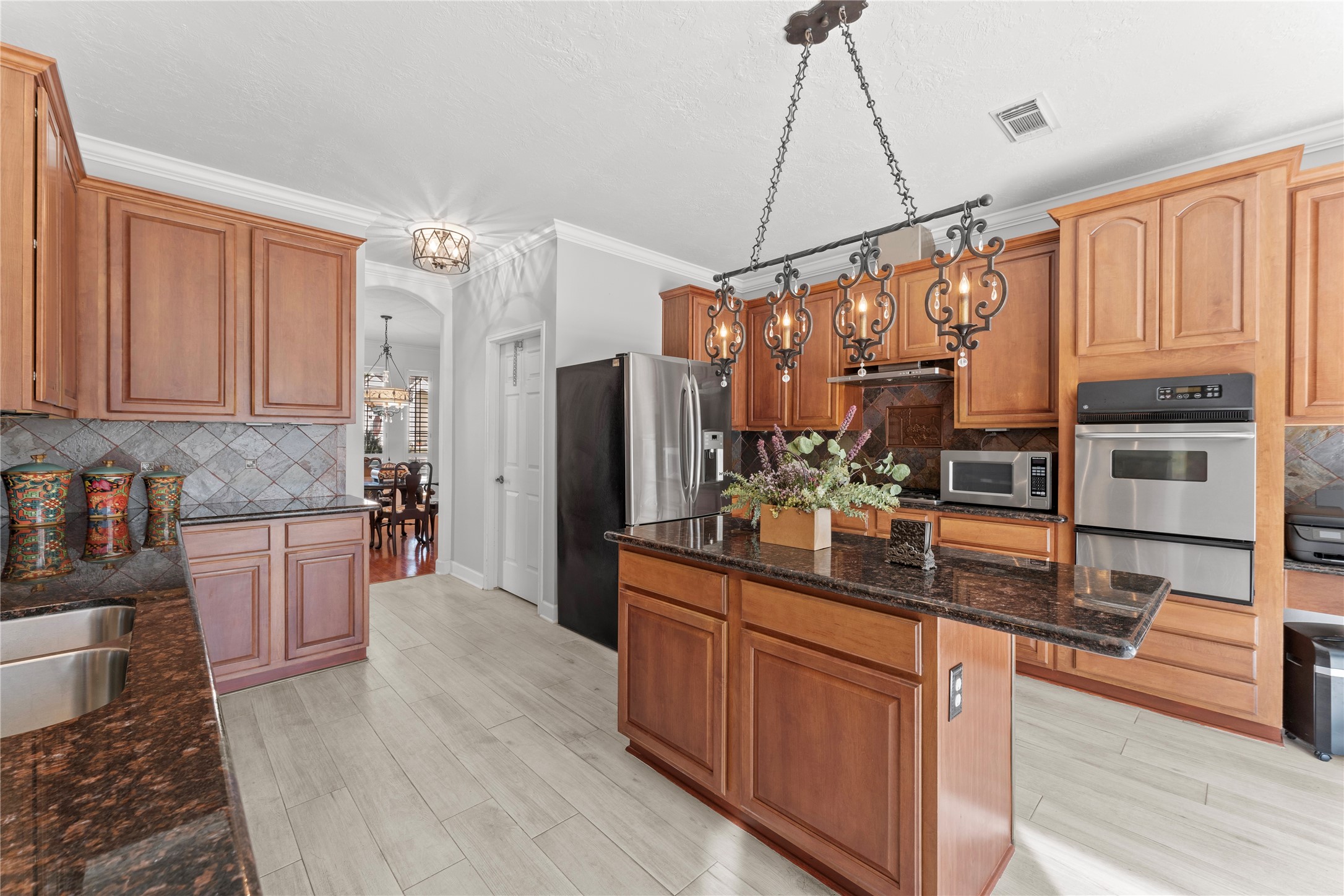 2922 Travick Lane Houston, TX 77073 - Photo 17 of 49 a kitchen with stainless steel appliances kitchen island granite countertop a refrigerator a stove and a wooden cabinets