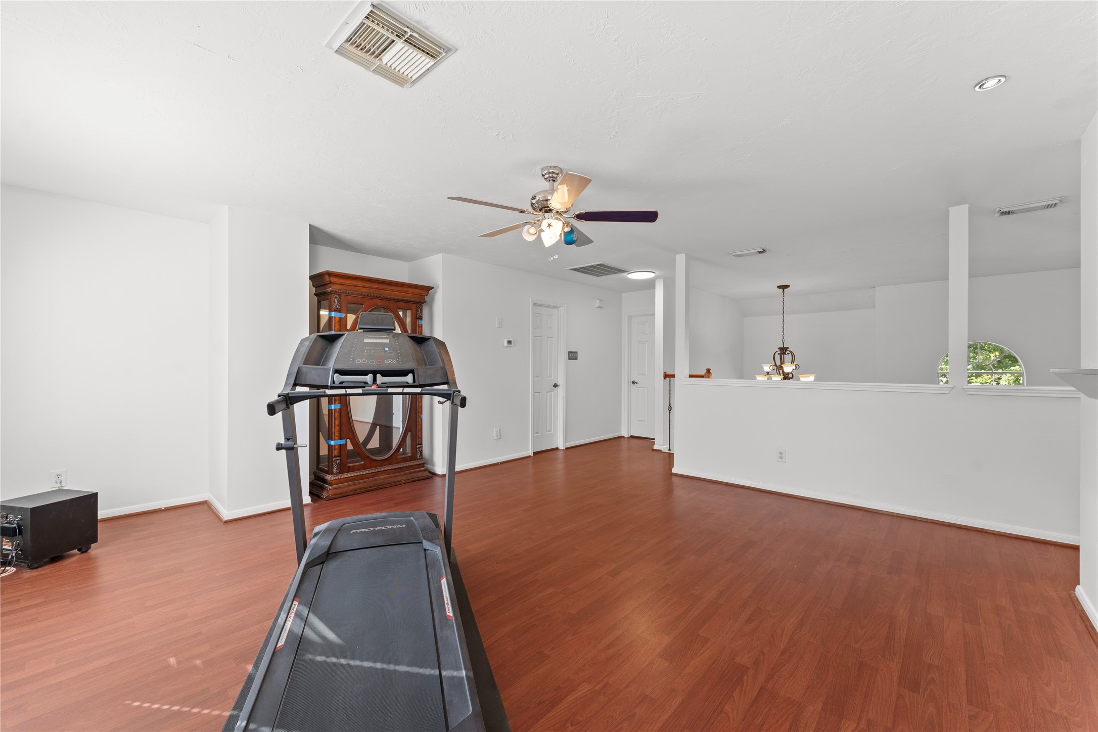 2922 Travick Lane Houston, TX 77073 - Photo 33 of 49 a view of an empty room with a ceiling fan and wooden floor