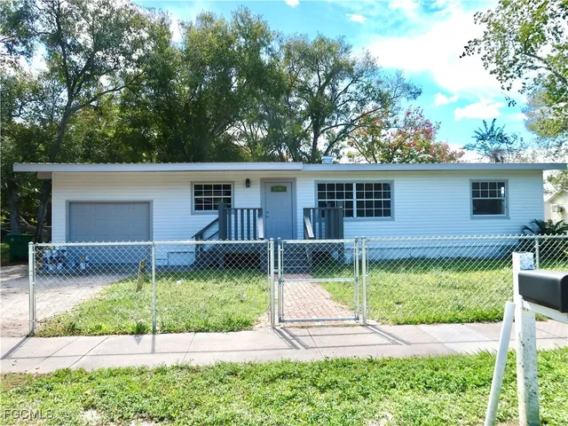 a view of a house with backyard and sitting area