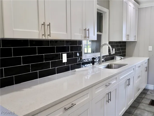 a kitchen with a sink a stove and cabinets
