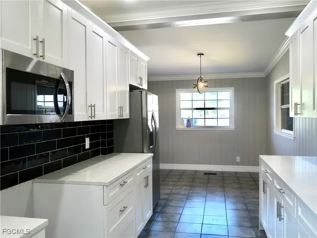 a kitchen with granite countertop a stove a sink and a microwave