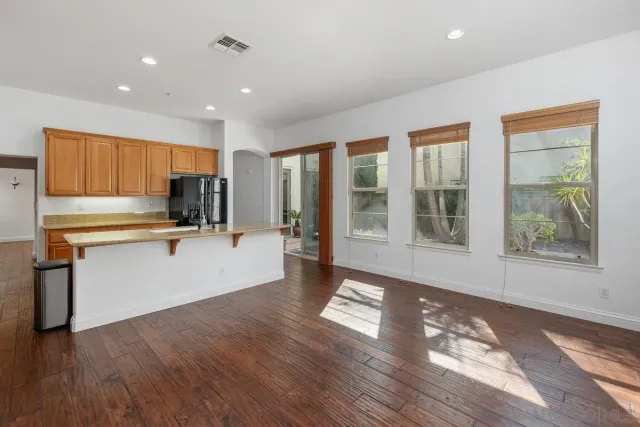 a view of a kitchen with wooden floor and electronic appliances