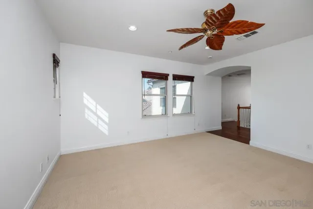 an empty room with windows and fan