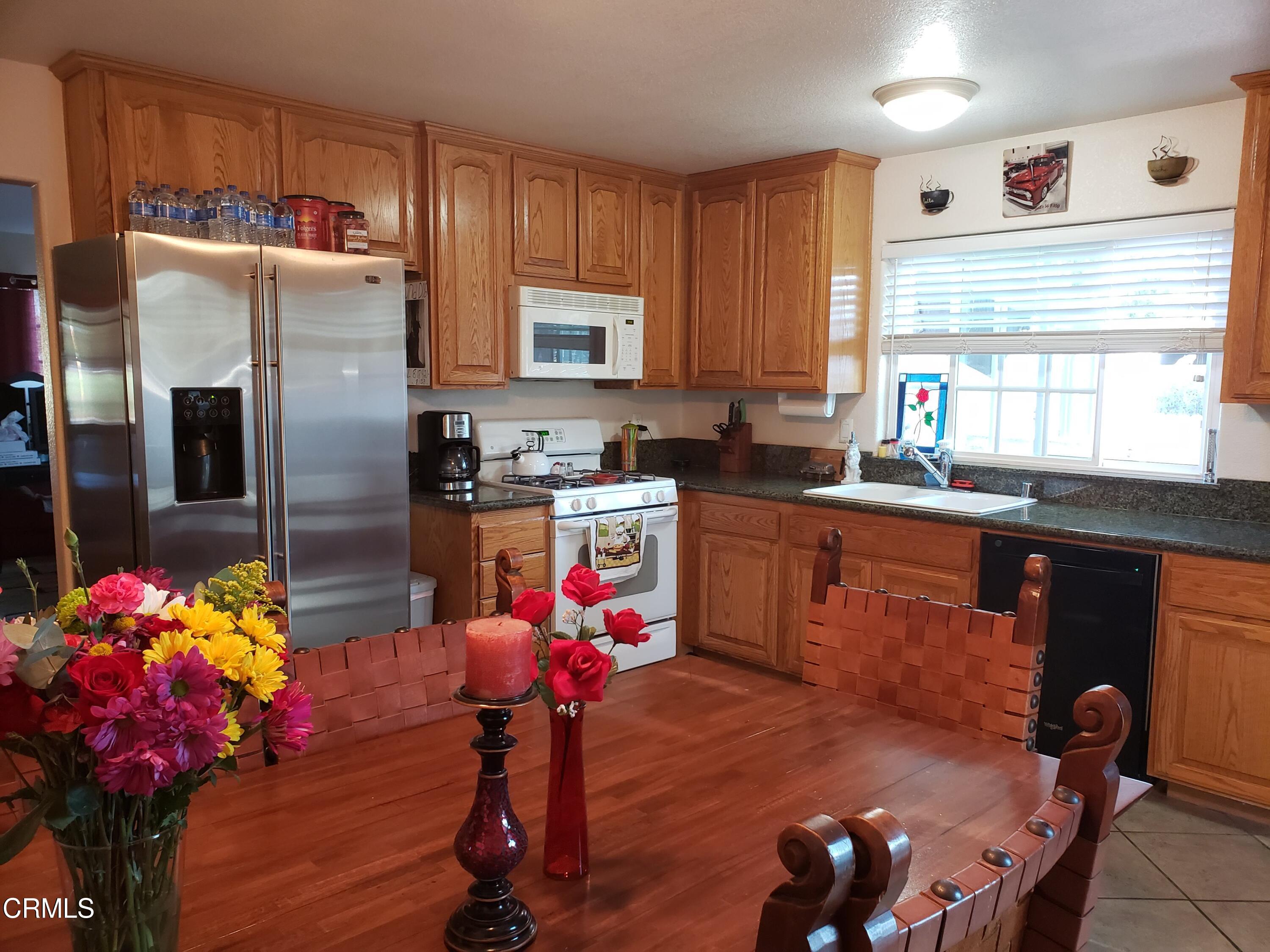 2059 Ralston Street Simi Valley, CA 93063 - Photo 13 of 34 a kitchen with granite countertop a sink appliances cabinets and dining table