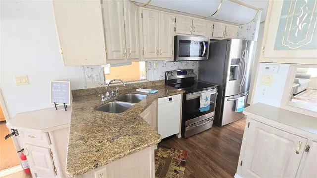 a kitchen with a stove a sink and a refrigerator
